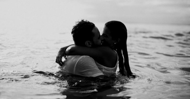 Beach Days - Man and Woman Kissing Together on Body of Water