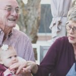 Seniors - Grandmother and Grandfather Holding Child on Their Lap