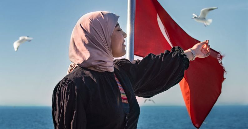 Cruise Itinerary - A woman in a hijab on a boat with birds flying