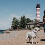 Lighthouse - A Woman Posing with her Dog on the Beach