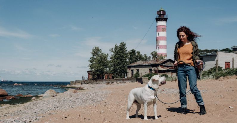Lighthouse - A Woman Posing with her Dog on the Beach