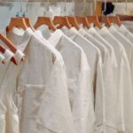 Basics - Clothes in Neutral Colors Hanging on the Racks in a Clothing Store