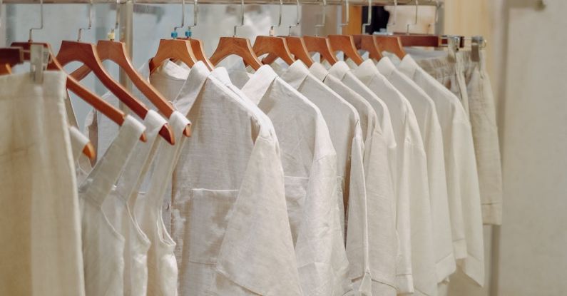 Basics - Clothes in Neutral Colors Hanging on the Racks in a Clothing Store