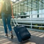 Packing - Woman Walking on Pathway While Strolling Luggage